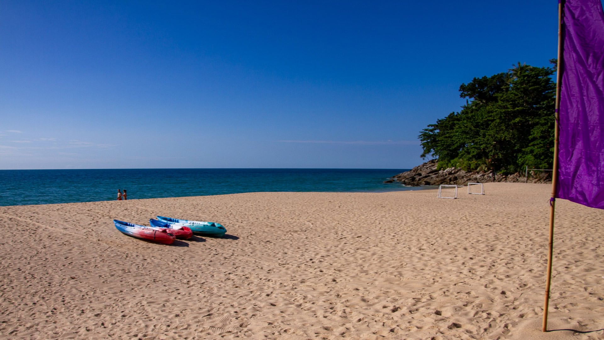 White Beach Phuket central sandy shoreline with people walking near the surf.
