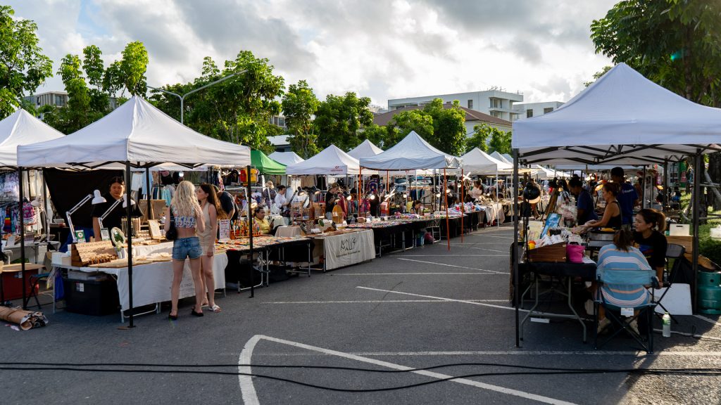 Fun Friday Boat Avenue Market Phuket with food stalls set up on a parking lot, tables covered with prepared food and no cars present