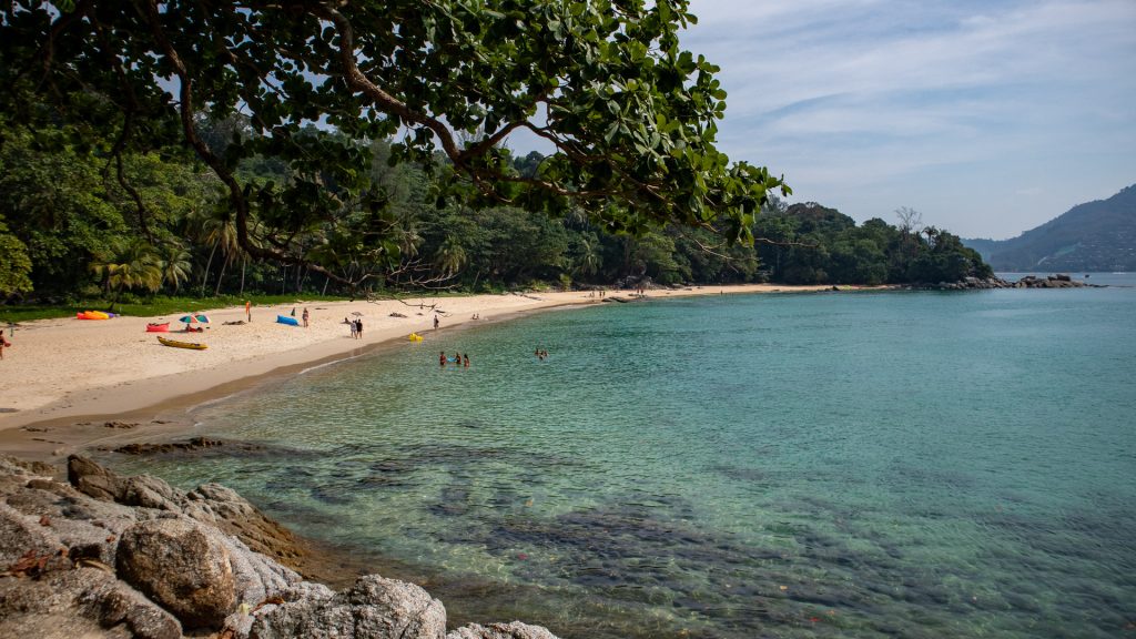 Fine sand and tree-lined shoreline at Laem Singh Beach Phuket seen from the southern side.