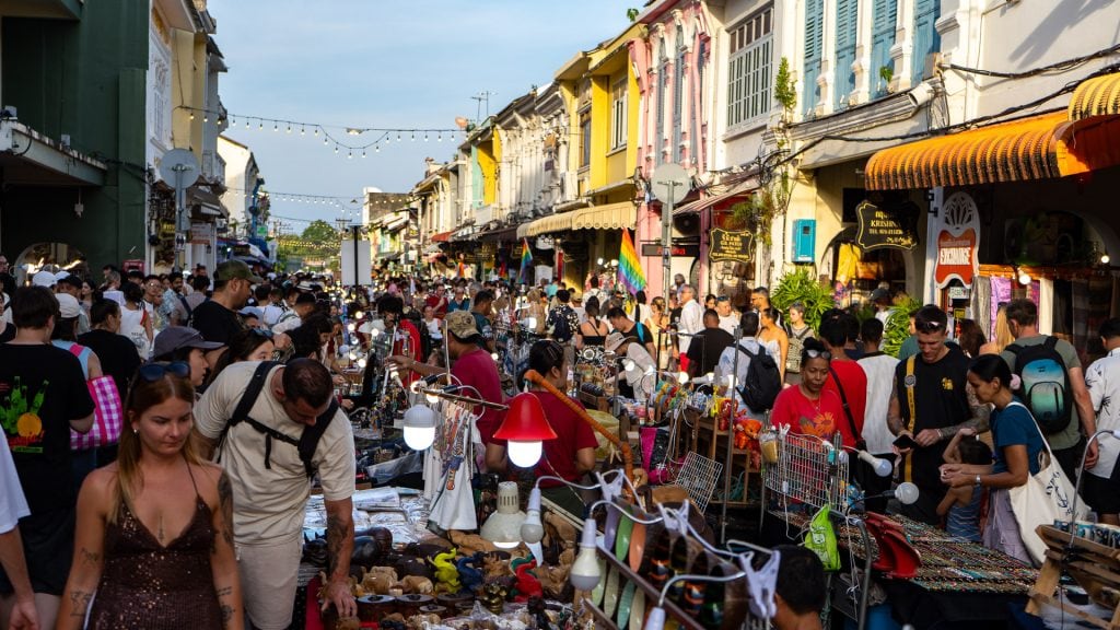 Lard Yai Sunday Night Market Phuket wide street view with food and craft stalls on both sides, hanging lights above the road, and visitors walking and browsing along the market.