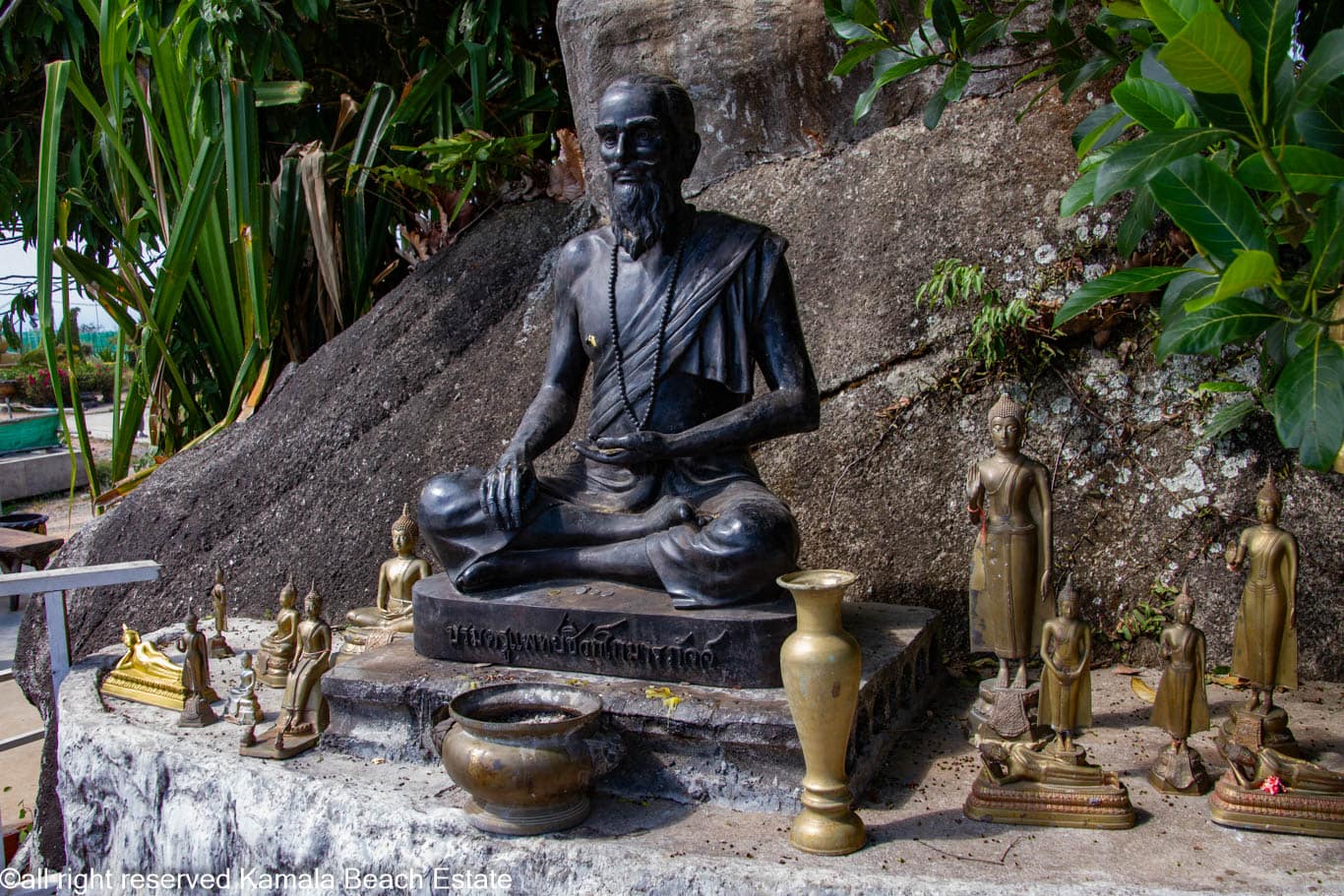 Seated monk statue with smaller Buddha figures at Big Buddha Phuket