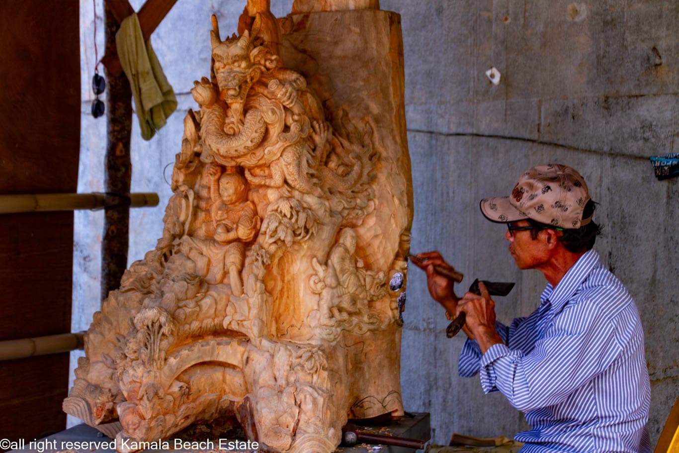 Woodcarver chiselling an ornate relief at Big Buddha Phuket
