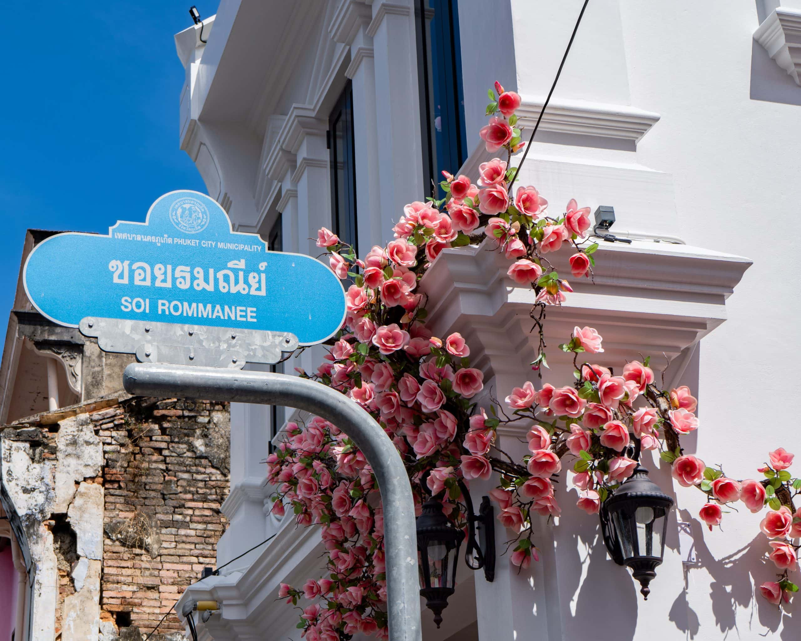 Soi Rommanee street sign and decorative flowers in Phuket Old Town