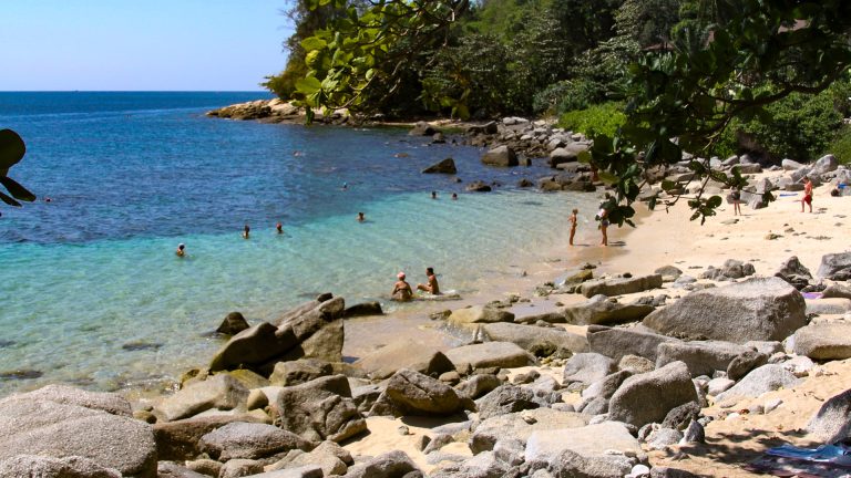 Ao Sane Beach Phuket rocky beach section with uneven sand and stones.