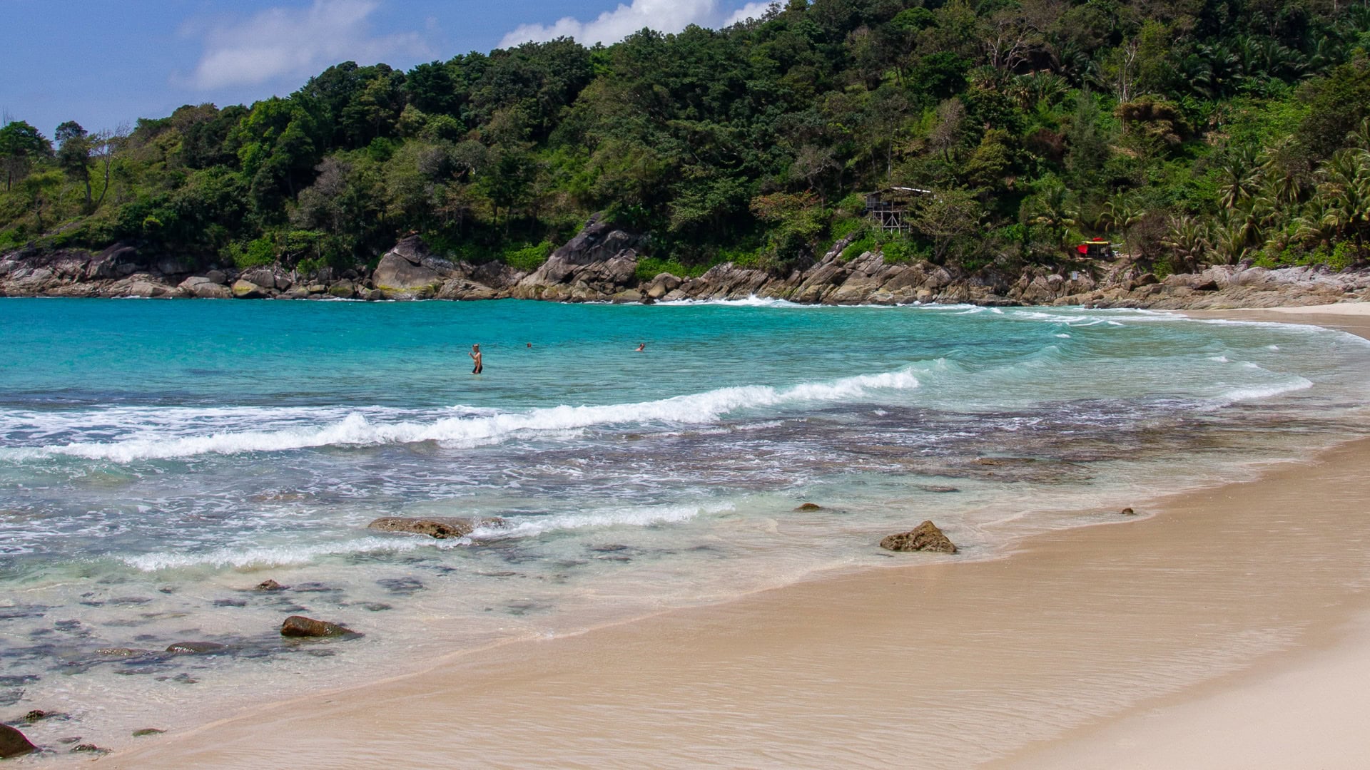 Freedom Beach Phuket shallow water with swimmers and rocky seabed