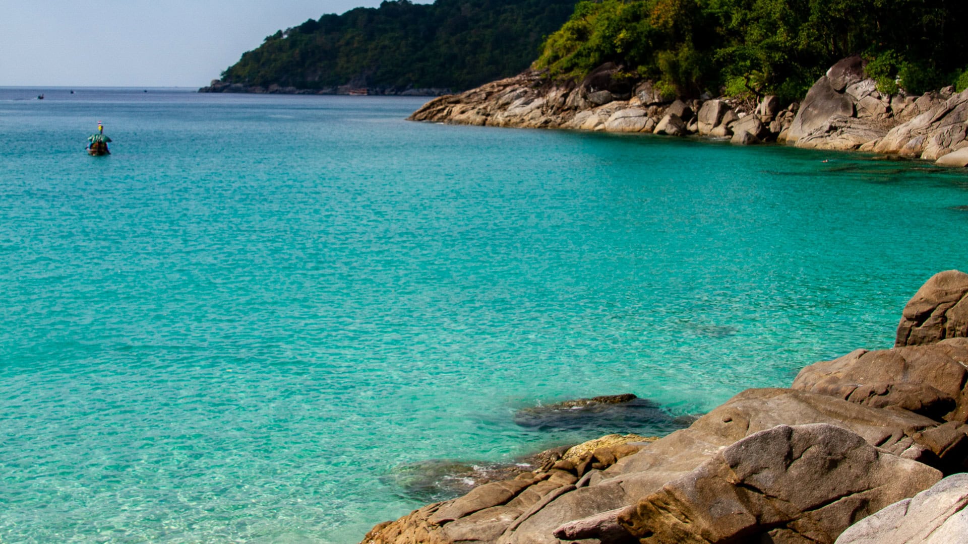 Freedom Beach Phuket aerial-style view with longtail boats and swimmers