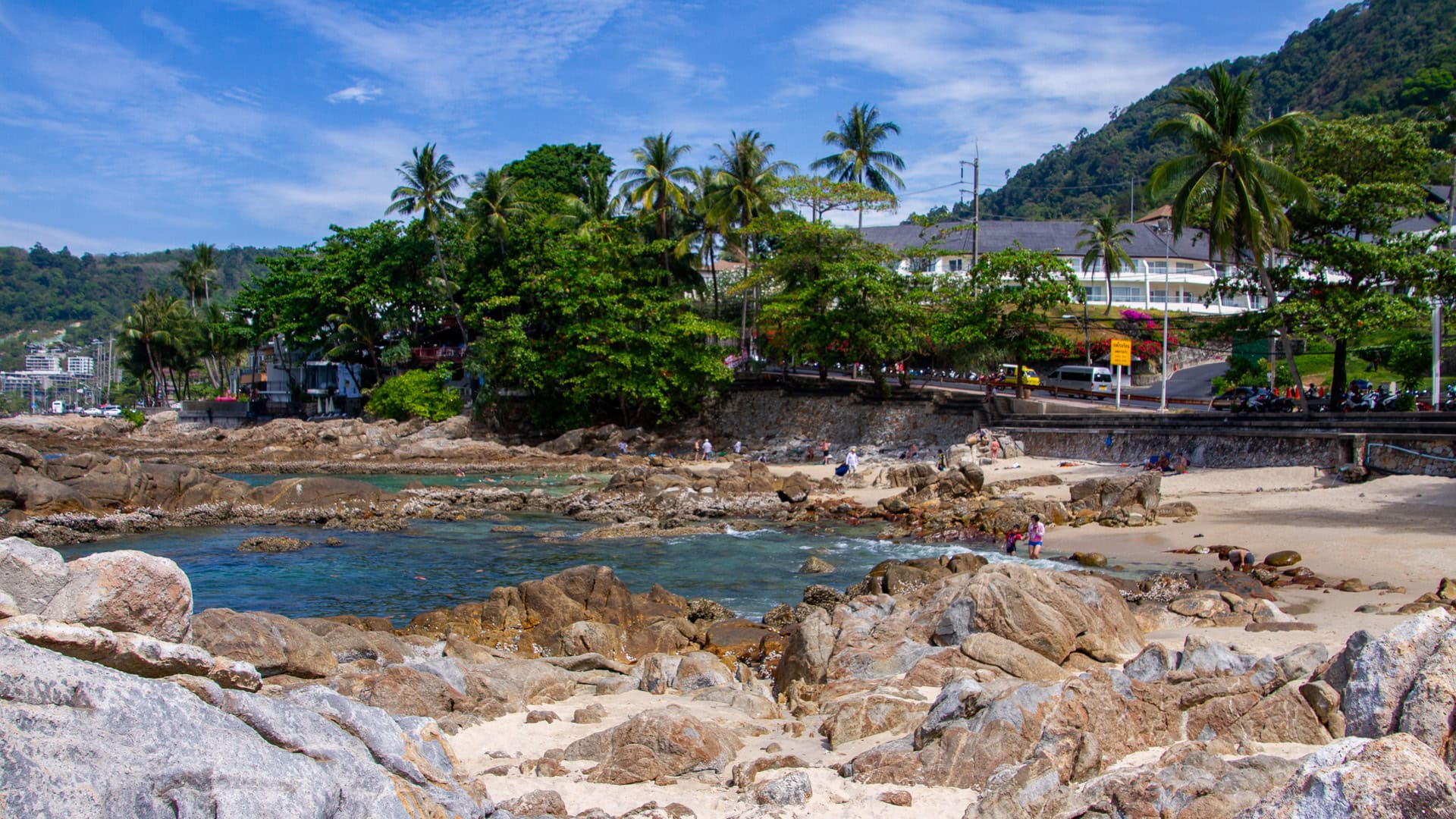 Kalim Beach Phuket shoreline at sunset with rocks and gentle surf