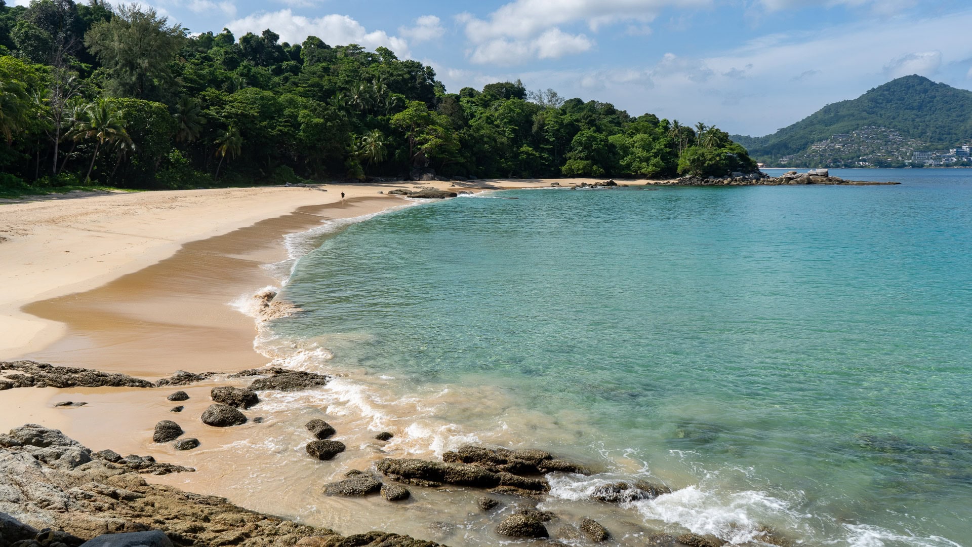 Open sand curve and calm dry-season water at Laem Singh Beach Phuket.