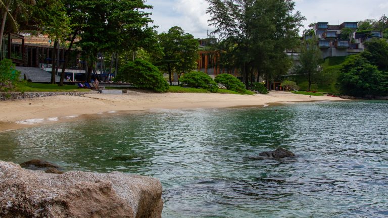 Yae Beach Phuket with clear water and a rocky seabed.