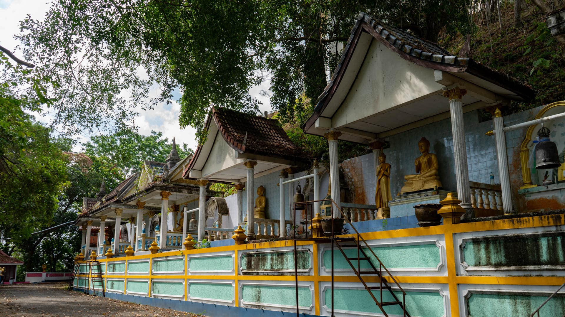 Row of memorial shrine niches with Buddha statues at Wat Ban Koh Sirey