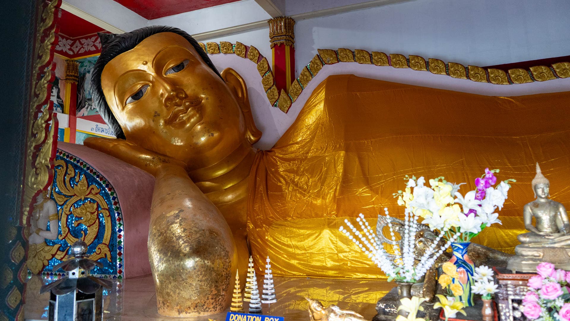 Reclining Buddha statue inside temple hall at Wat Ban Koh Sirey