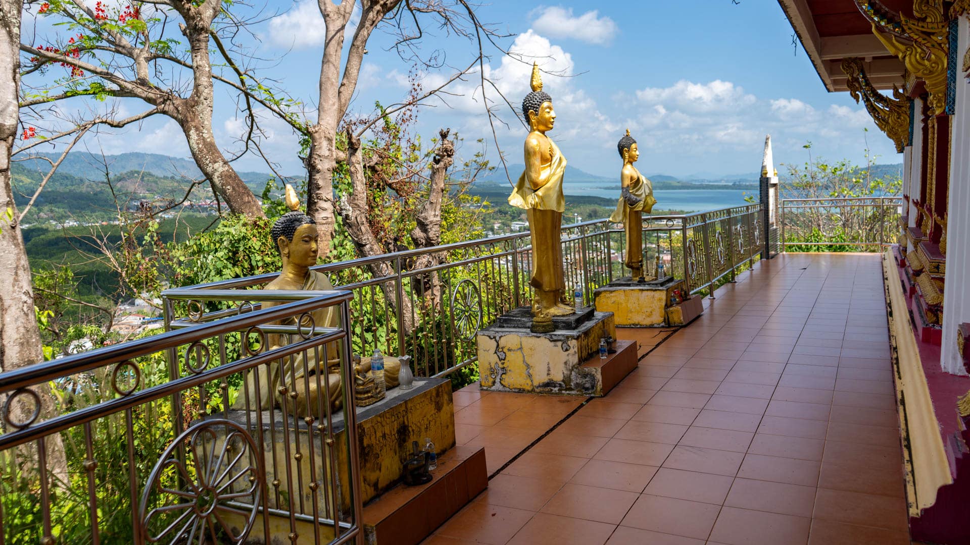 Standing Buddha statues along terrace overlooking Sapam Bay at Wat Ban Koh Sirey