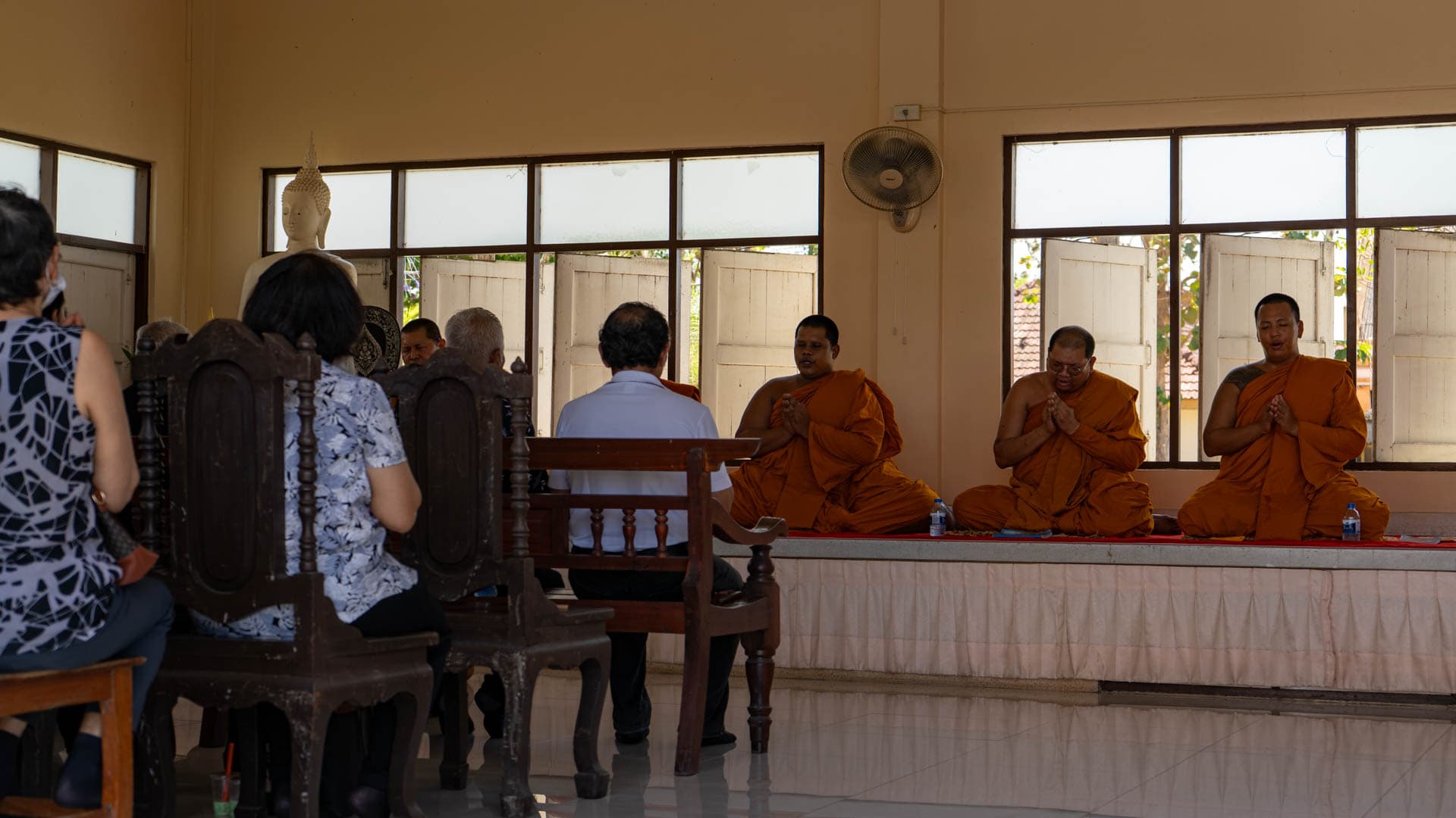 Buddhist monks chanting during a ceremony inside a prayer hall at Wat Chalong Phuket