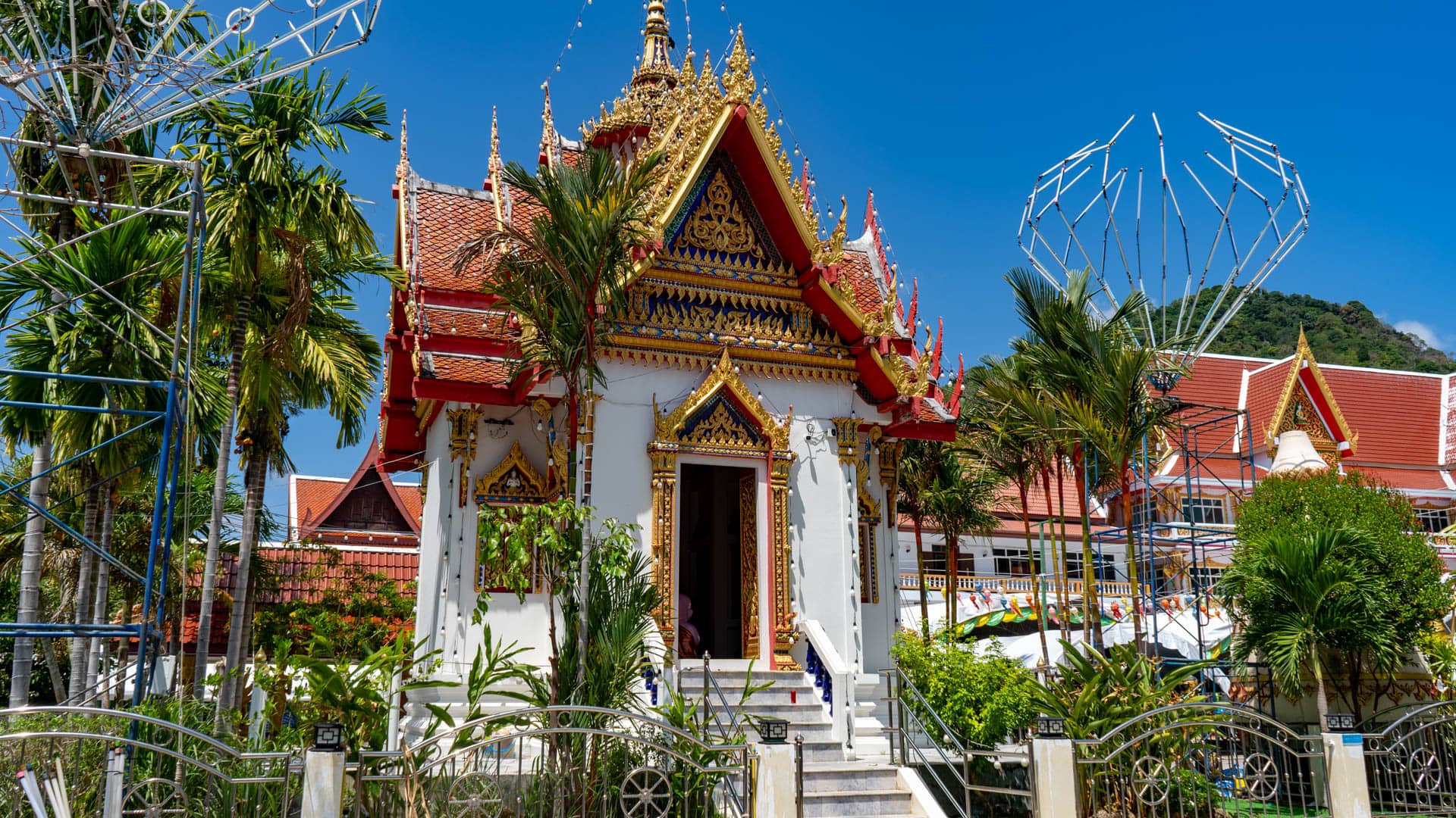 Temple hall entrance with steps and palm trees at Wat Karon Phuket