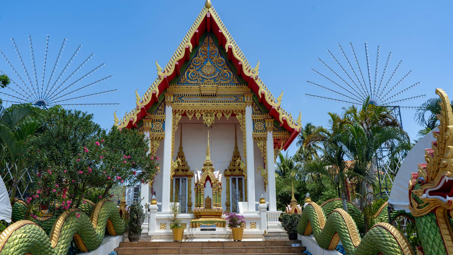 Temple stairway with green naga serpent sculptures leading to shrine hall at Wat Karon