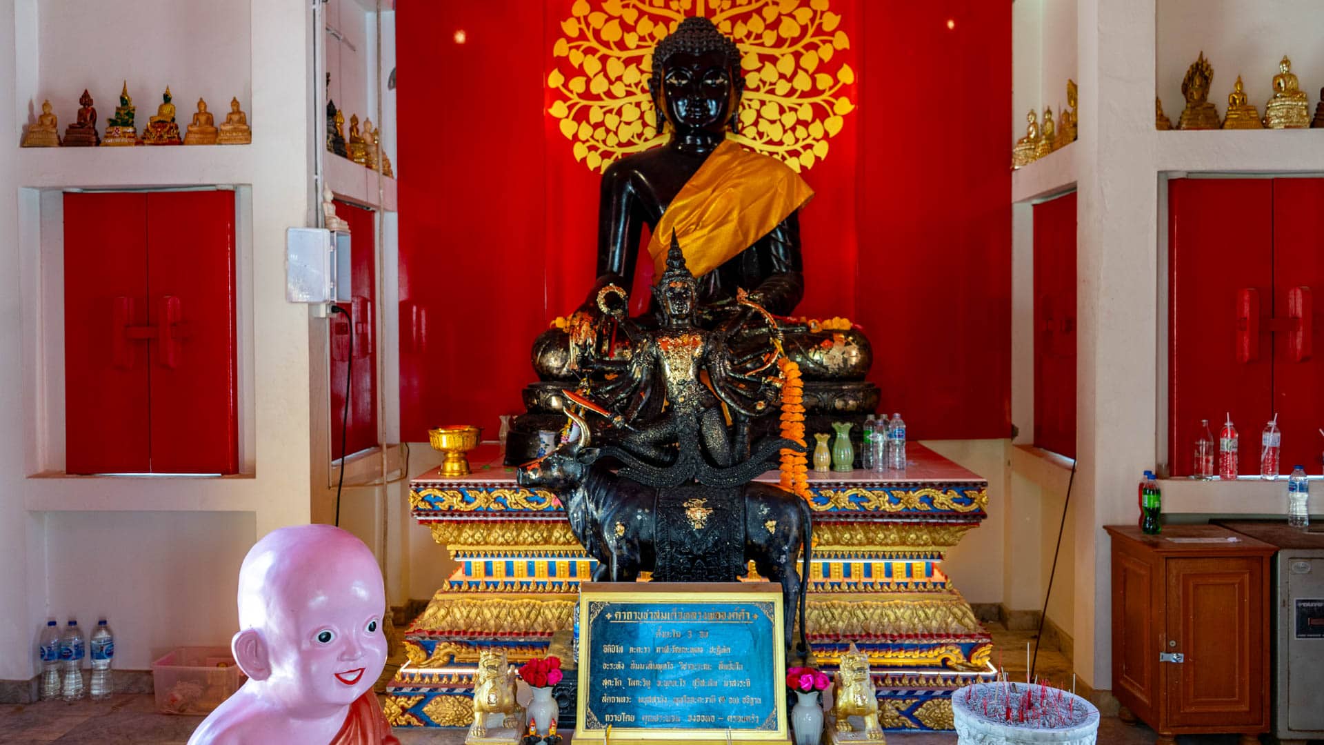 Black seated Buddha statue on altar inside Wat Karon shrine hall