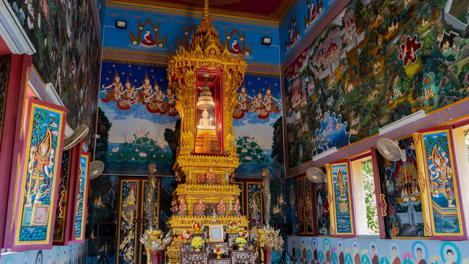 Colorful Buddhist mural painting covering interior wall of temple hall