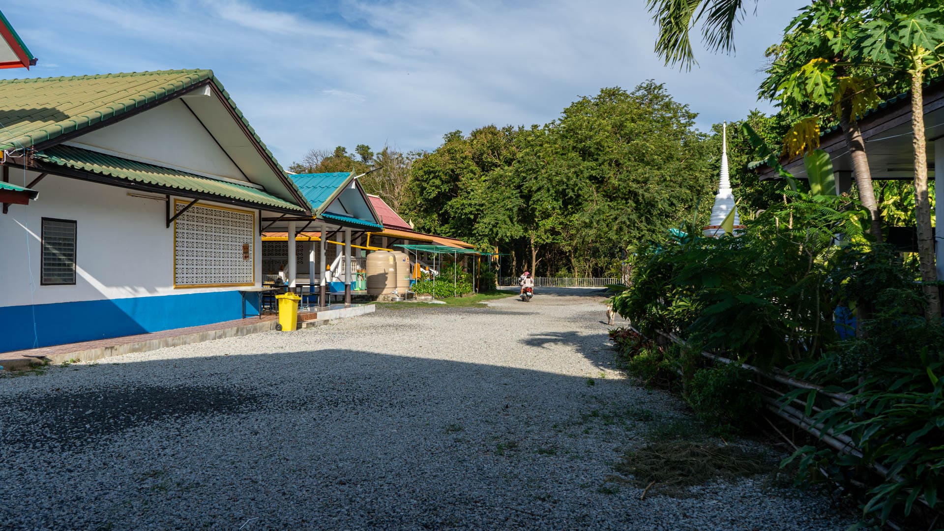 Gravel courtyard and temple buildings at Wat Laem Phromthep on Phromthep Cape hillside