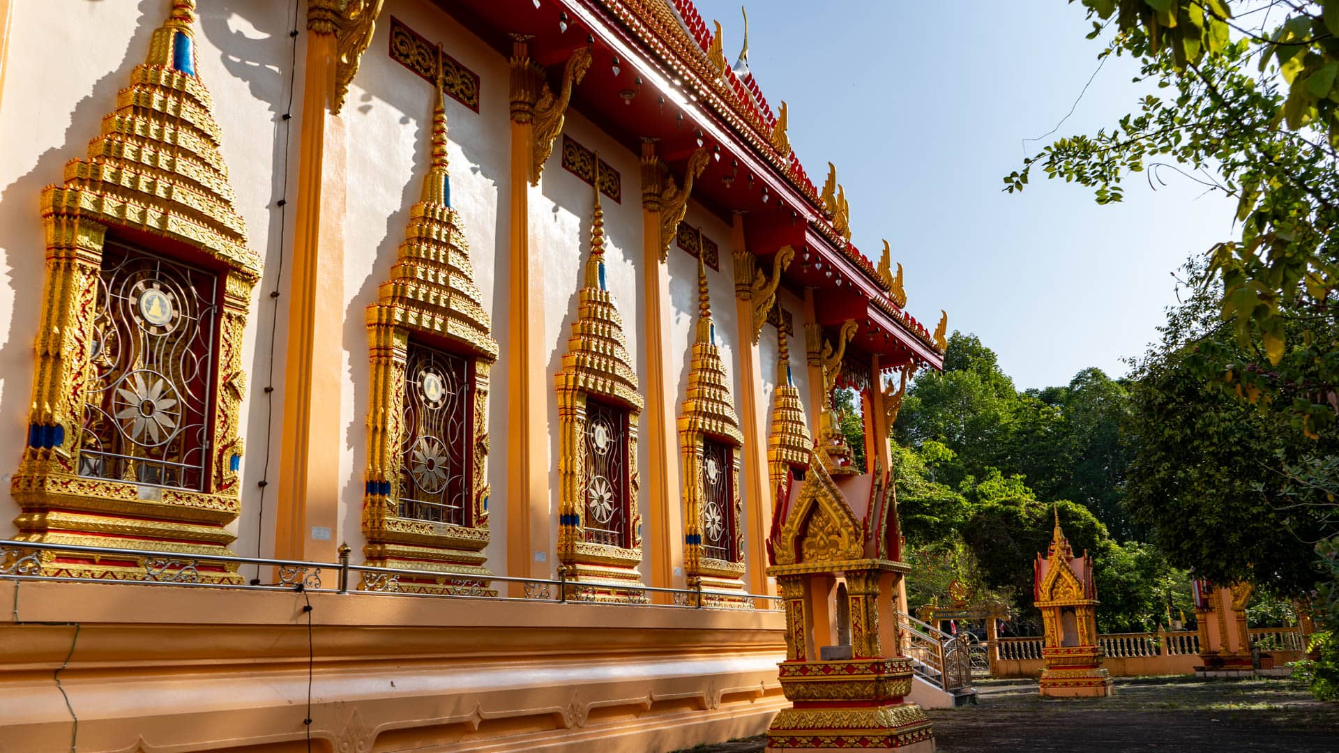 Gilded windows and roof supports along Wat Phra Thong main hall