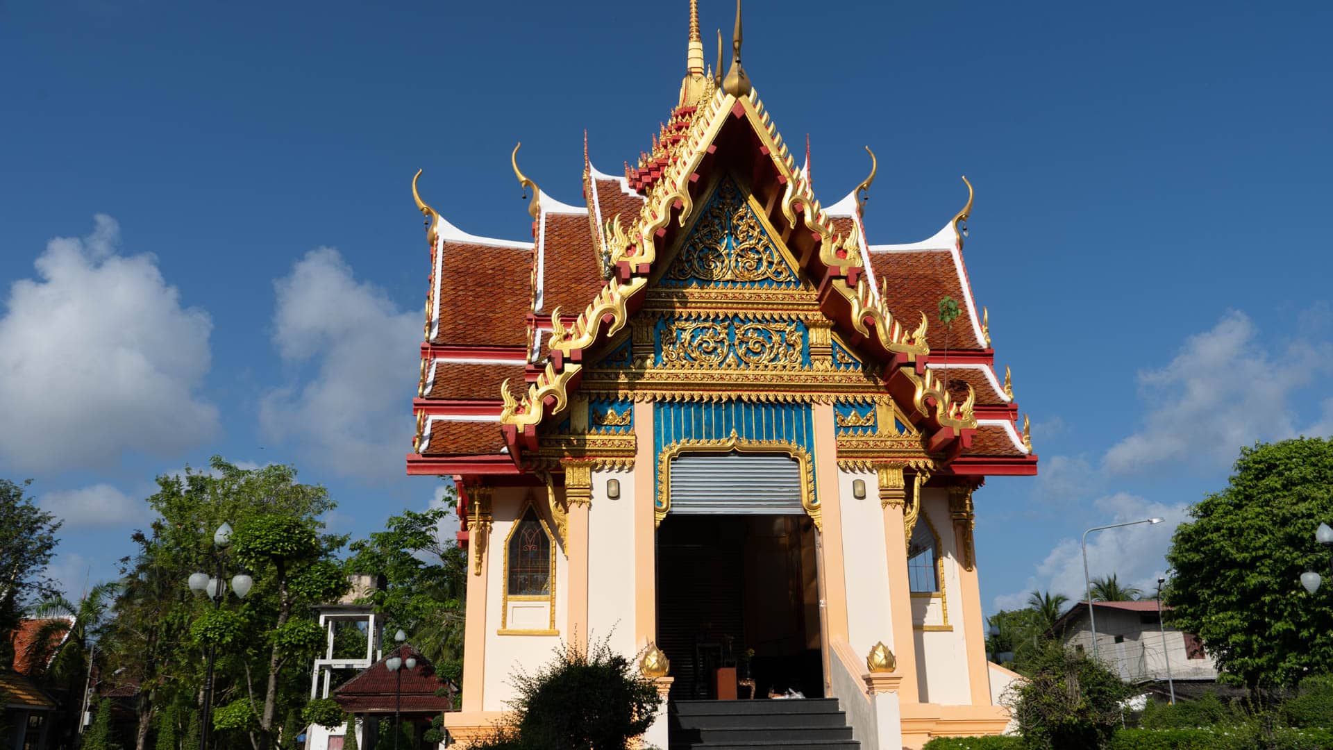 Secondary temple hall with layered roof and steps at Wat Phra Thong