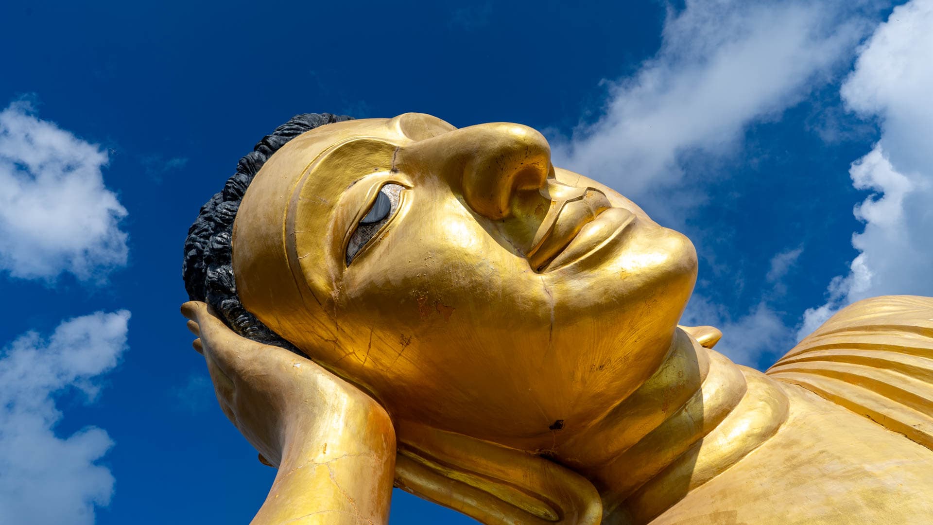 Close view of reclining Buddha face and hand at Wat Sri Sunthon