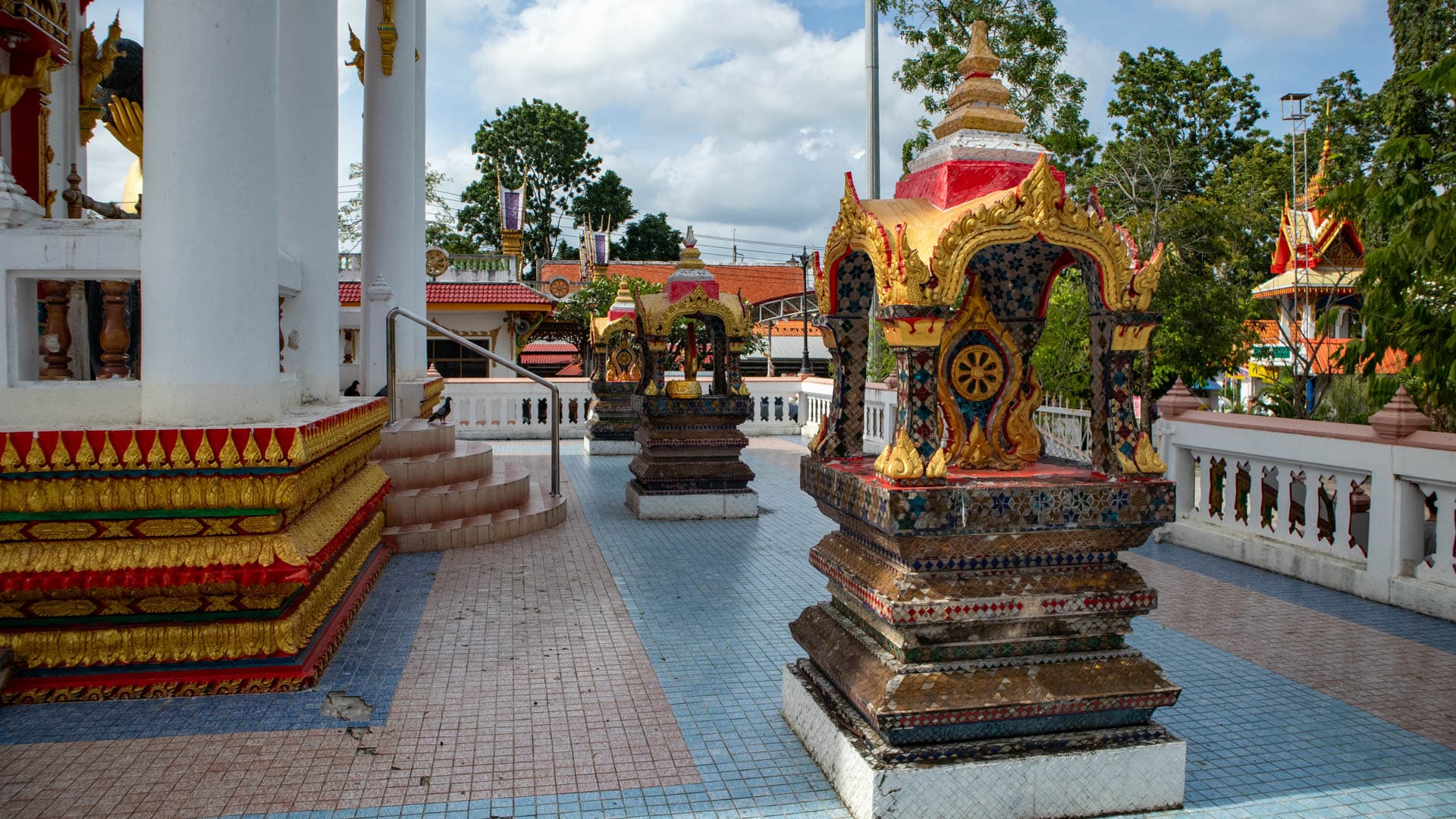 Small shrine structures on tiled terrace at Wat Sri Sunthon