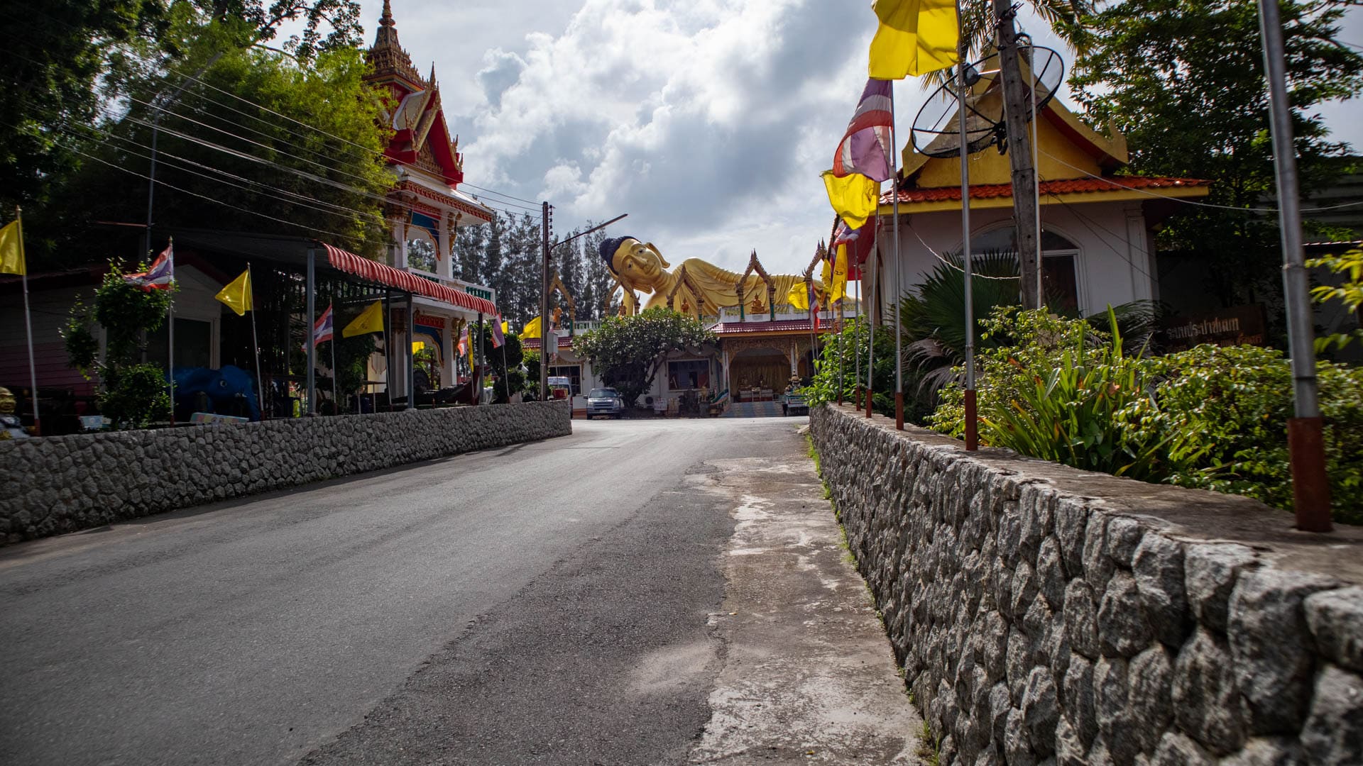 Road approach to Wat Sri Sunthon with reclining Buddha in distance