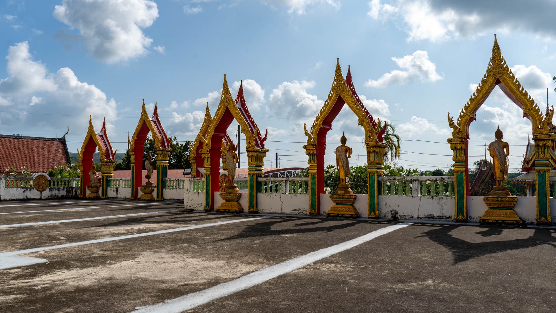 Row of arches and standing Buddha figures at Wat Sri Sunthon